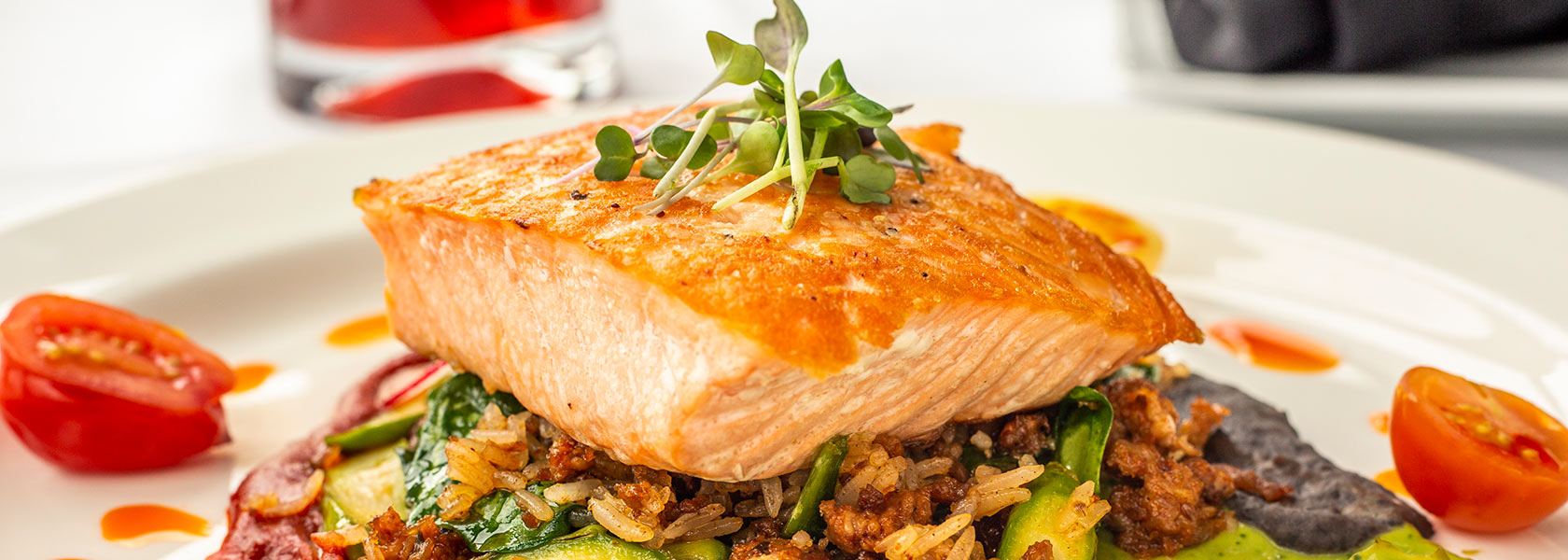 Pan-seared salmon plated on wild rice with cocktail