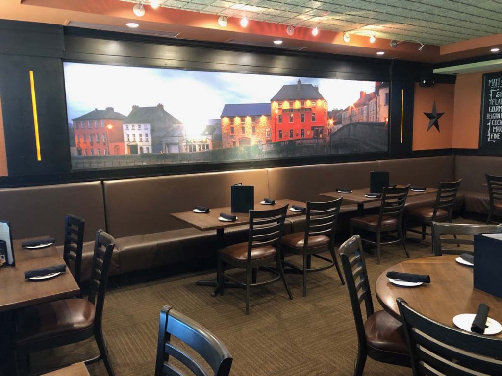 Indoor dining room with wall mural of Irish pubs at Matt the Miller’s Tavern in Dublin, Ohio