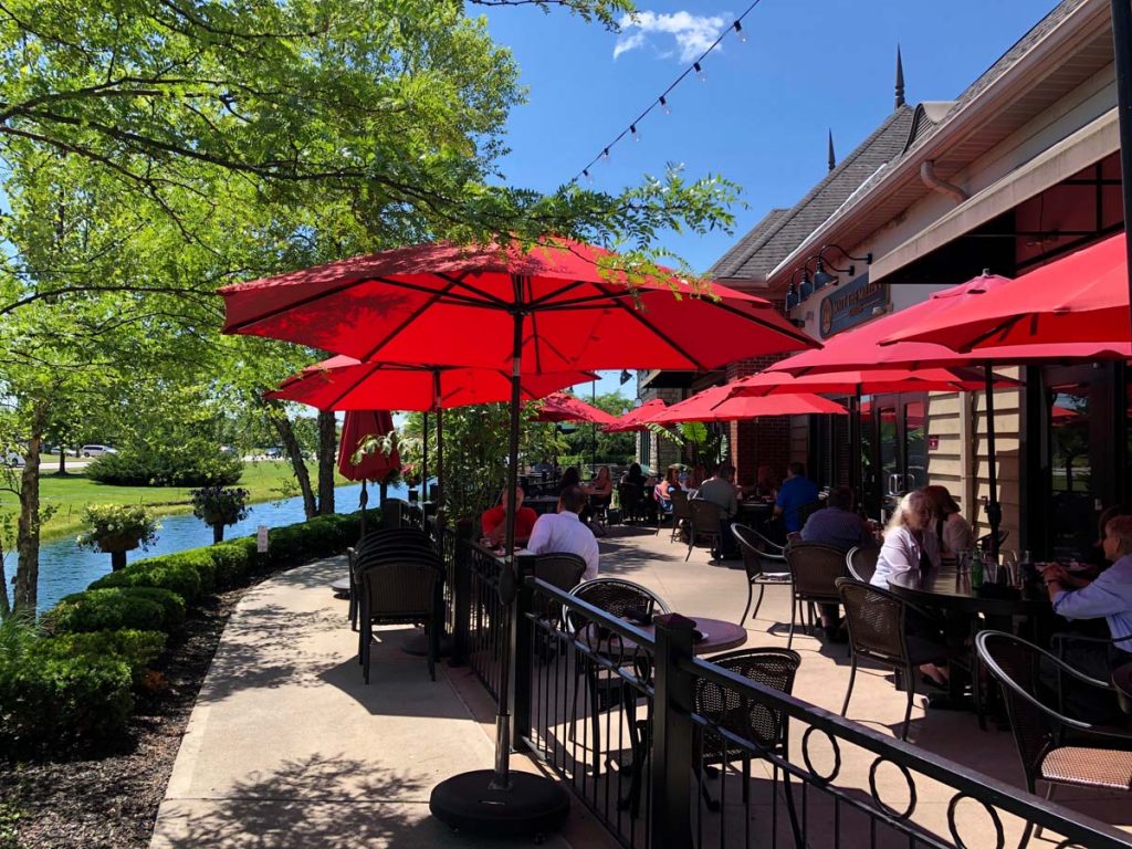 Outdoor patio seating with red umbrellas at Matt the Miller’s Tavern in Dublin, Ohio